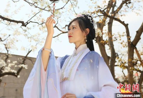 圖為蘭州青年身穿漢服在百年梨園賞景?！「哒?攝