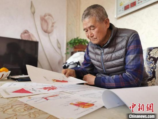 圖為陸鵬飛向記者展示多年帶隊(duì)的手寫筆記?！堟?攝