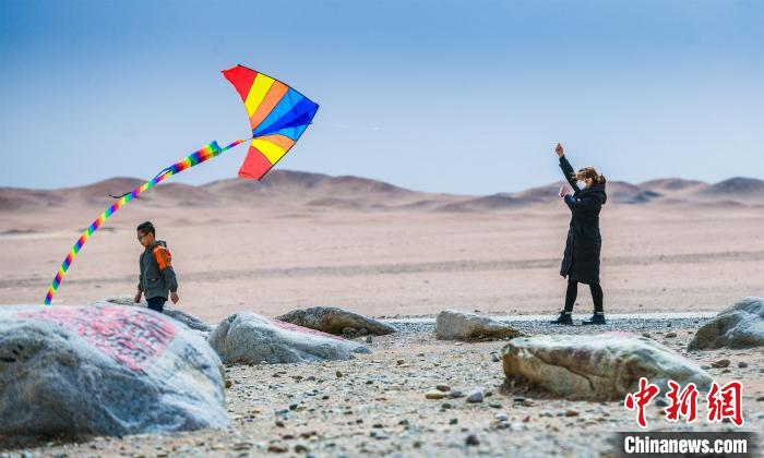 圖為市民正在陽關(guān)景區(qū)放風(fēng)箏。　王斌銀 攝