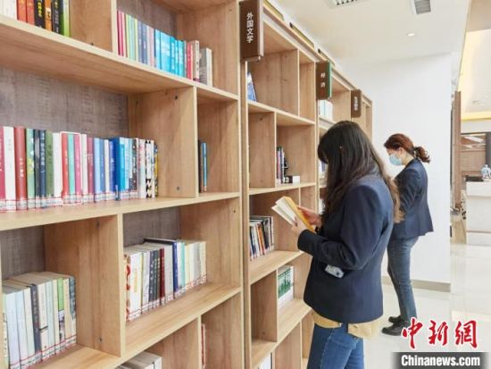 圖為在甘肅公航旅建設(shè)集團有限公司的職工書屋，職工挑選書籍?！⌒煅?攝
