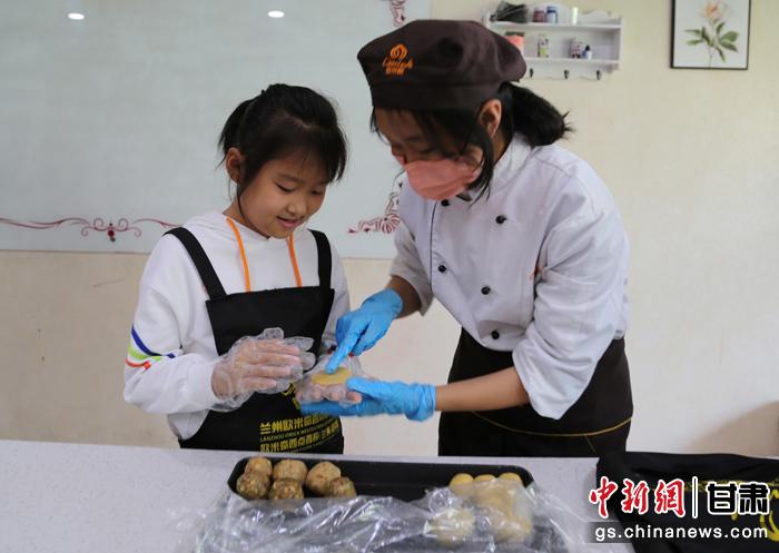 圖為在甘臺(tái)胞小朋友在工作人員指導(dǎo)下制作月餅。九美旦增 攝