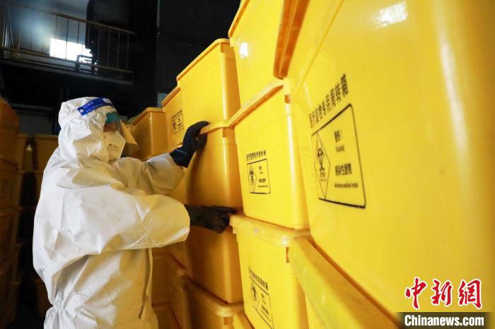 圖為工作人員搬運醫(yī)療廢物專用周轉(zhuǎn)箱。　魏建軍 攝