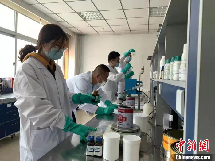 圖為肖菲(前一)帶領團隊研發(fā)水性涂料。(資料圖) 受訪者供圖