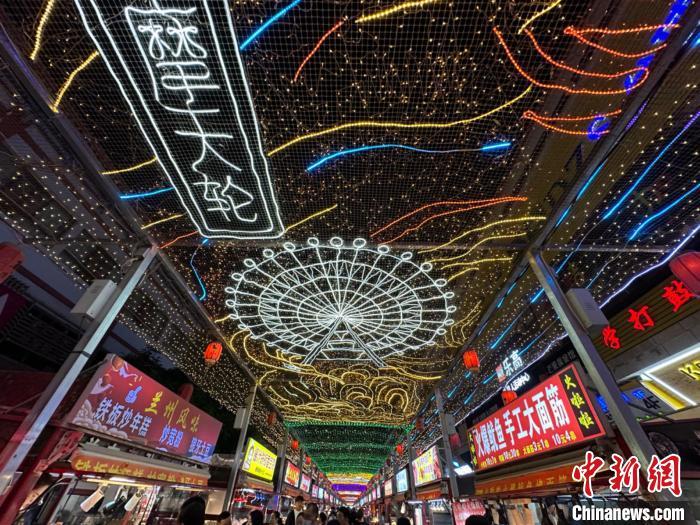 圖為明清街夜市燈光點(diǎn)亮具有武威文化元素的“摩天輪”彩燈?！〈魑牟?攝</p><p>