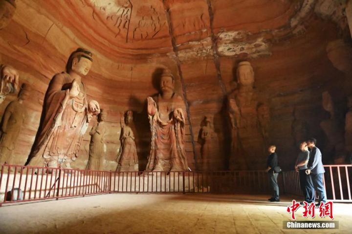 7月15日，游人參觀甘肅省平?jīng)鍪袥艽h百里石窟長廊中的南石窟寺1號(hào)窟。百里石窟長廊位于涇川縣境內(nèi)，由512個(gè)石窟、5眼窟中石井組成，現(xiàn)存王母宮石窟、鳳凰山石窟、南石窟寺、丈八寺石窟、羅漢洞石窟、太山寺石窟等規(guī)模較大的石窟群，還有數(shù)量眾多的小石窟群。南石窟寺開鑿于北魏永平三年，其中1號(hào)窟屬于大型七佛窟，七佛高達(dá)6米。中新社記者 李亞龍 攝