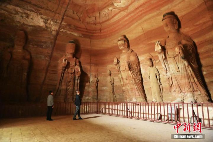 7月15日，游人參觀甘肅省平?jīng)鍪袥艽h百里石窟長廊中的南石窟寺1號(hào)窟。百里石窟長廊位于涇川縣境內(nèi)，由512個(gè)石窟、5眼窟中石井組成，現(xiàn)存王母宮石窟、鳳凰山石窟、南石窟寺、丈八寺石窟、羅漢洞石窟、太山寺石窟等規(guī)模較大的石窟群，還有數(shù)量眾多的小石窟群。南石窟寺開鑿于北魏永平三年，其中1號(hào)窟屬于大型七佛窟，七佛高達(dá)6米。中新社記者 李亞龍 攝