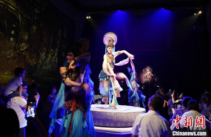 《樂動敦煌》是全球首部洞窟式沉浸體驗劇，利用真人與數(shù)字影像虛實交換實現(xiàn)沉浸式體驗。圖為2023年8月28日晚，《樂動敦煌》演出。(資料圖)中新社記者 毛建軍 攝